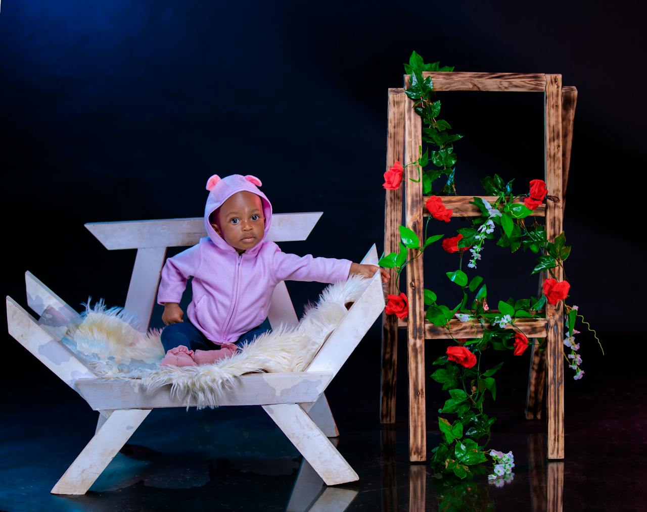 adorable-baby-in-pink-outfit-sitting-on-chair-30641108